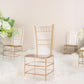 Clear and gold Chiavari chair-shaped party favor boxes on a soft background.