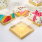 Clear and gold square mini dessert boxes with colorful treats inside.