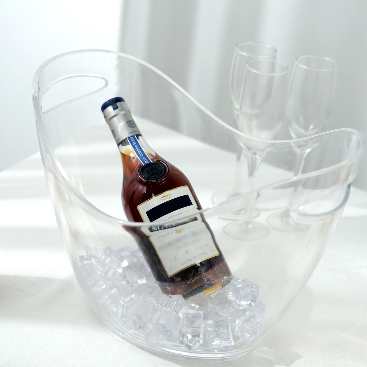 Clear plastic ice and drinks bucket with handles for party beverage storage.