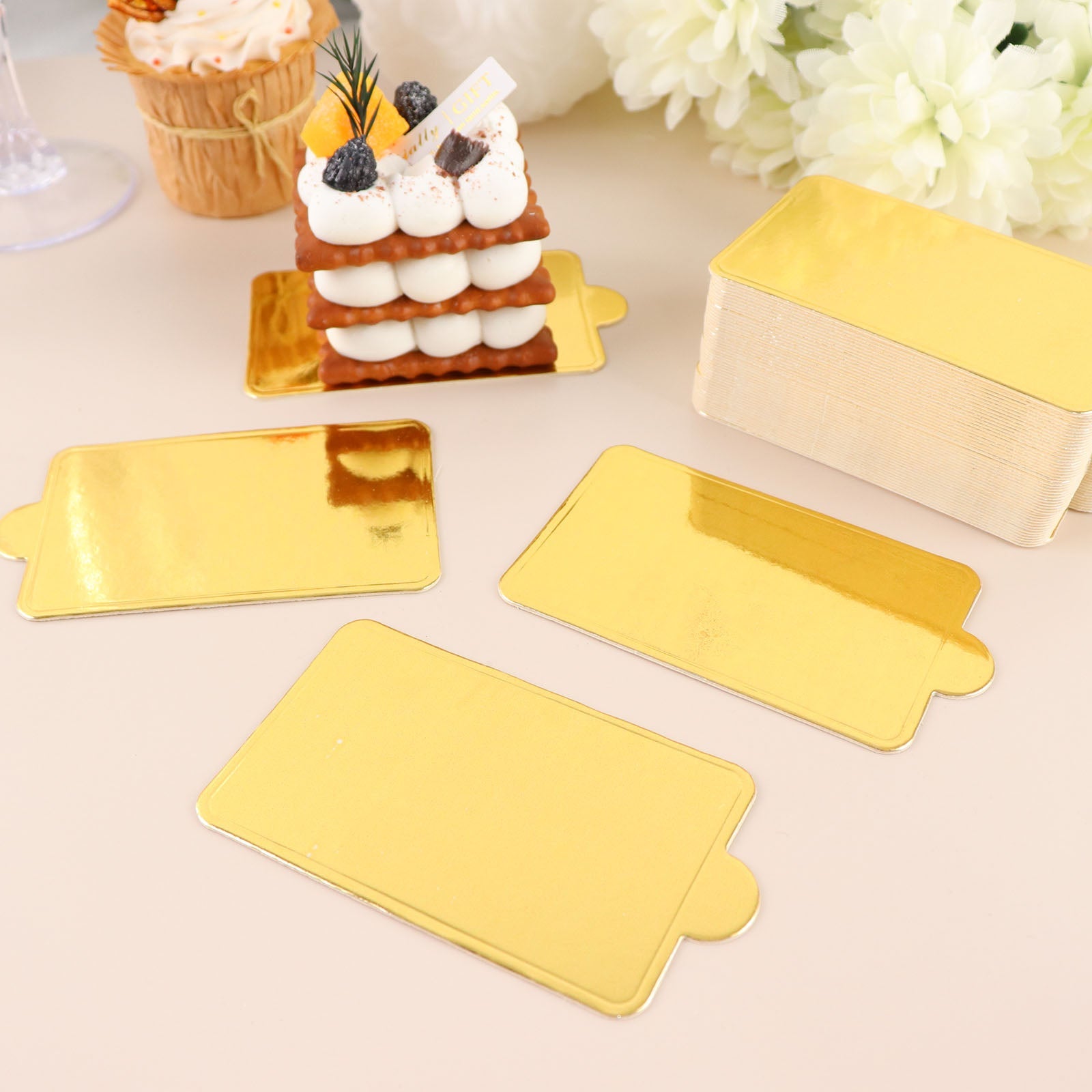 Mini gold rectangle dessert slice paper trays, perfect for cakes and desserts.