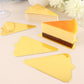Mini gold triangle dessert slice trays with a cake slice on a light background.