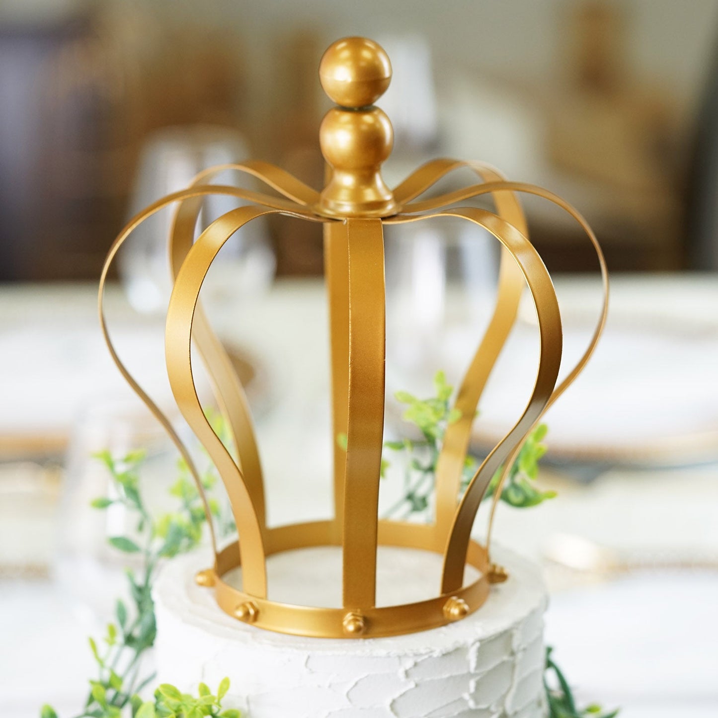 Matte gold metal royal crown cake topper for wedding decor.