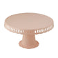 Blush round reusable plastic pedestal cake stand with scalloped edges.