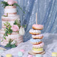 Pink donut bar display stand with colorful donuts at a wedding party.