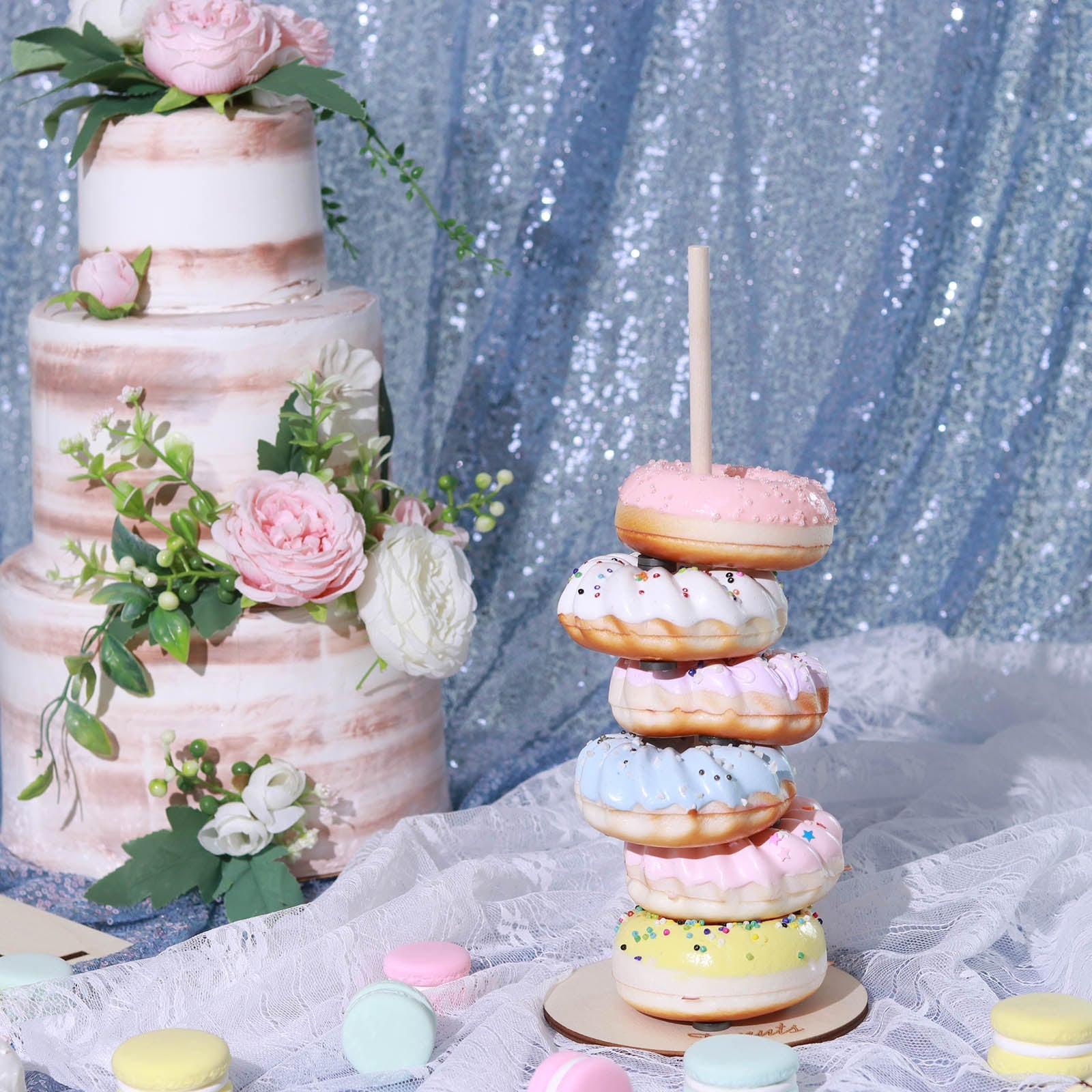 Pink donut bar display stand with colorful donuts at a wedding party.