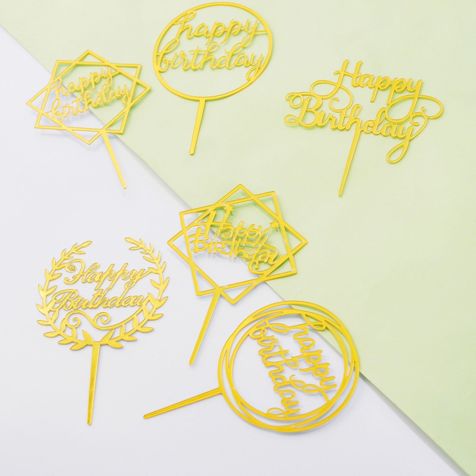 Gold acrylic happy birthday cake toppers in assorted styles.