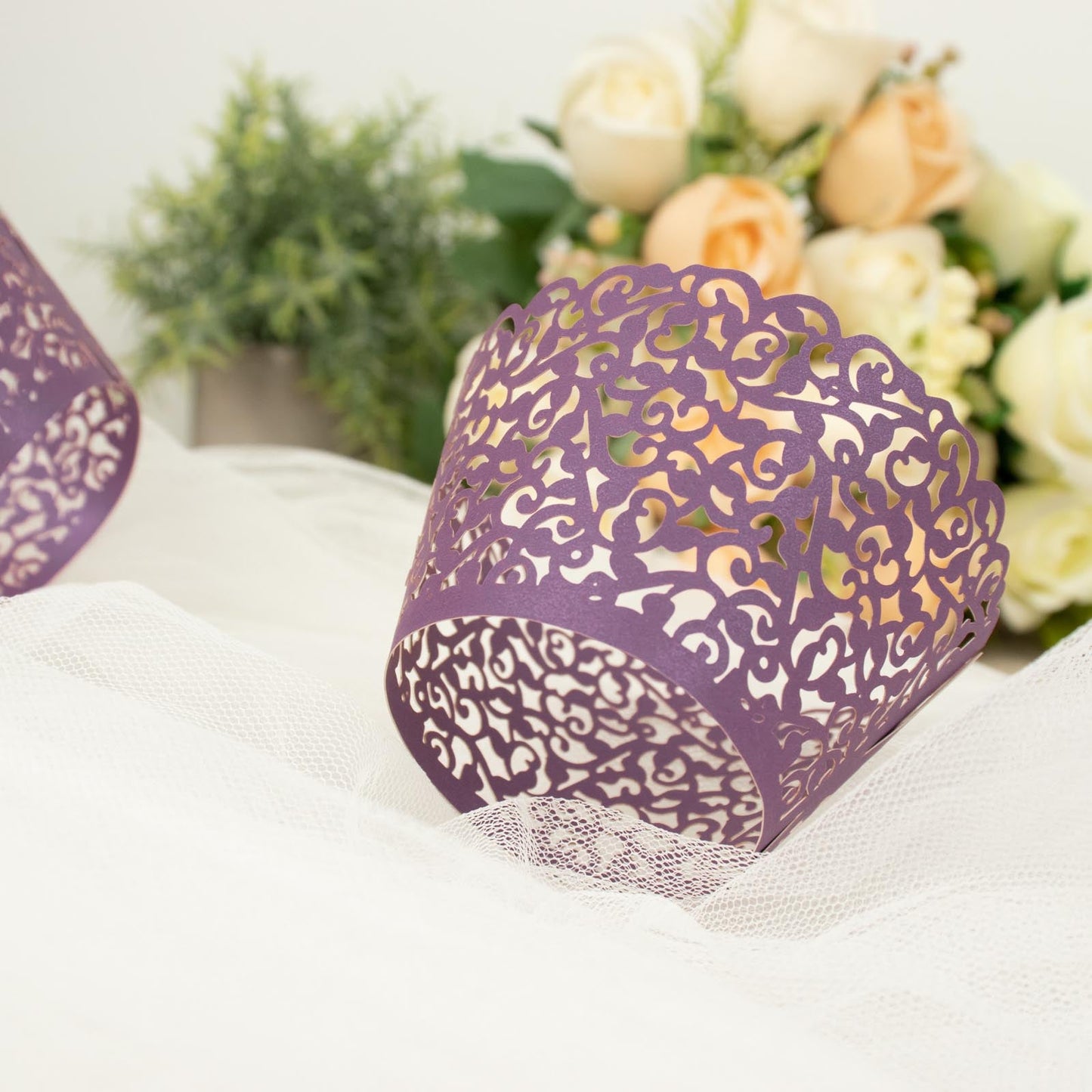 Purple lace laser cut cupcake wrappers with floral background.