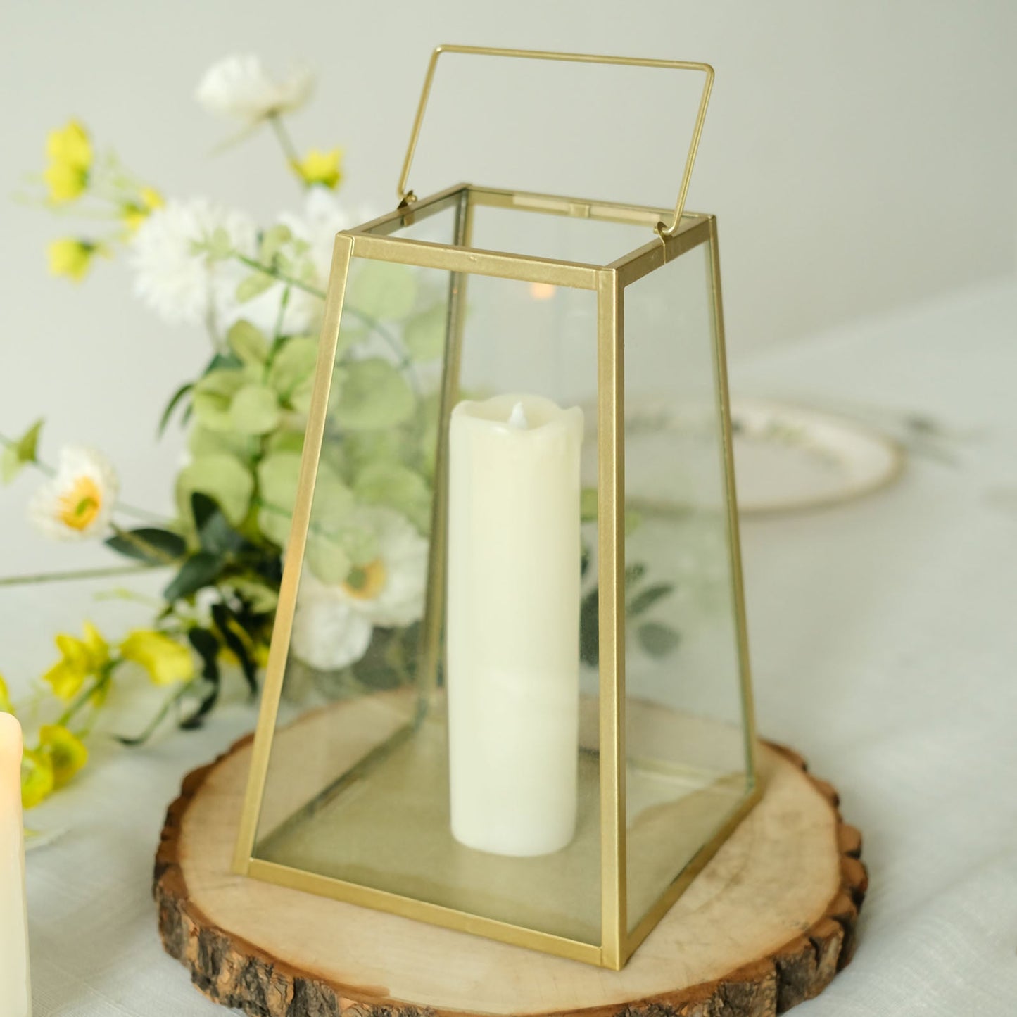 Gold geometric candle lantern with a white candle, perfect for table centerpieces.