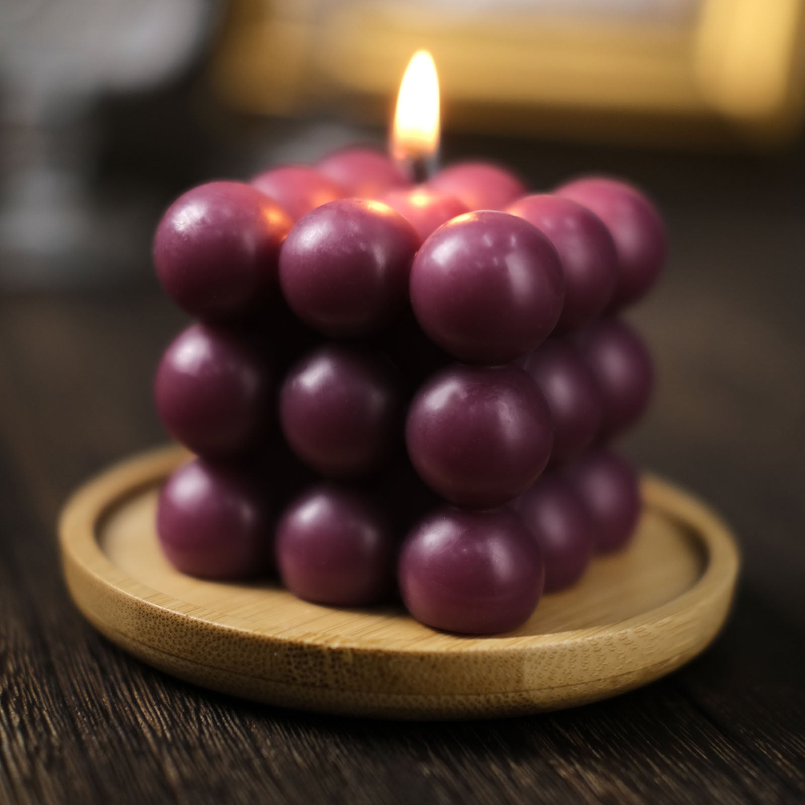 Burgundy bubble cube decorative candle with a warm glow.