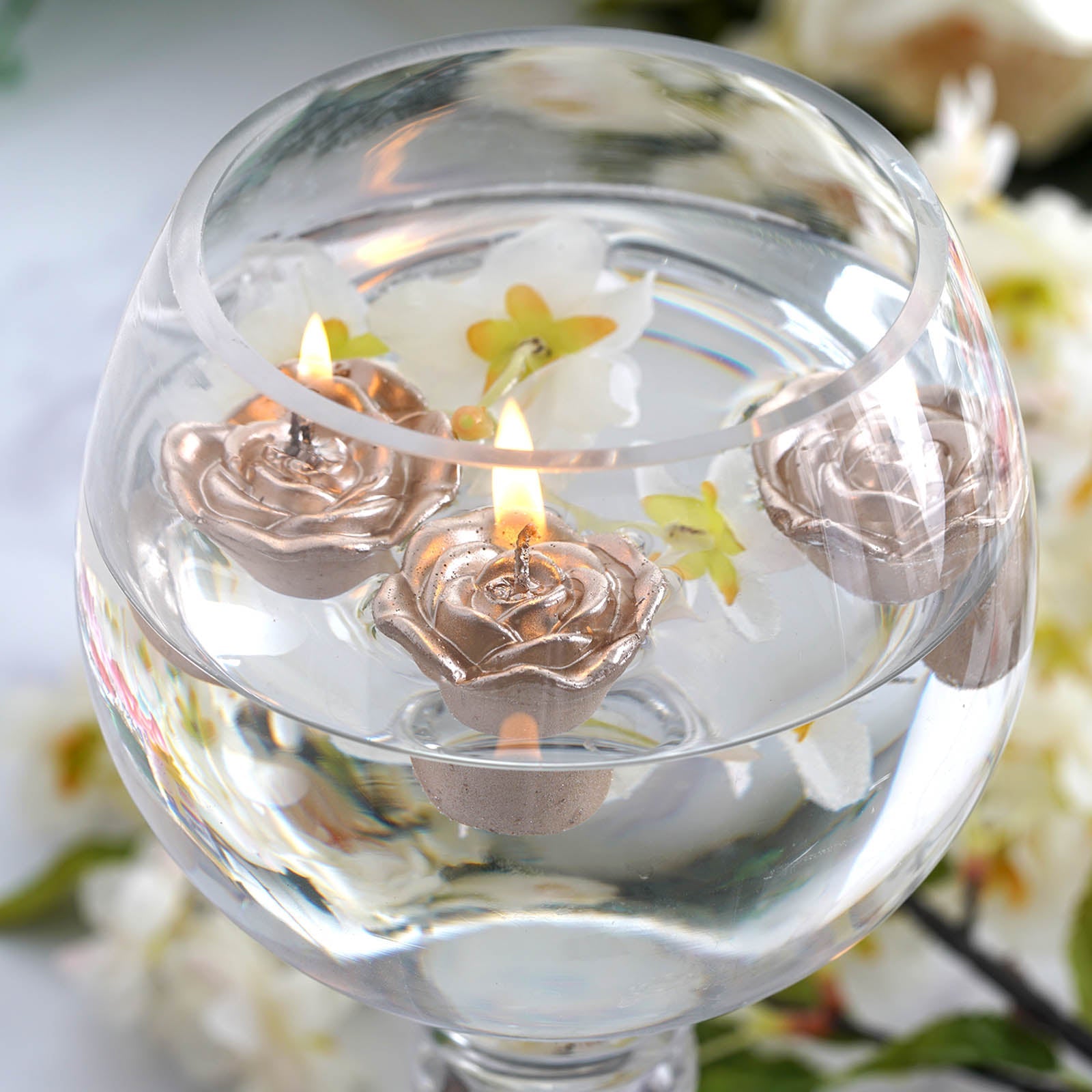 Rose gold mini rose floating candles in clear water vase.