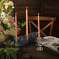 Blush premium unscented spiral wax taper candles in candle holders.
