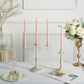 Blush pink spiral taper candles on a decorative candle holder.