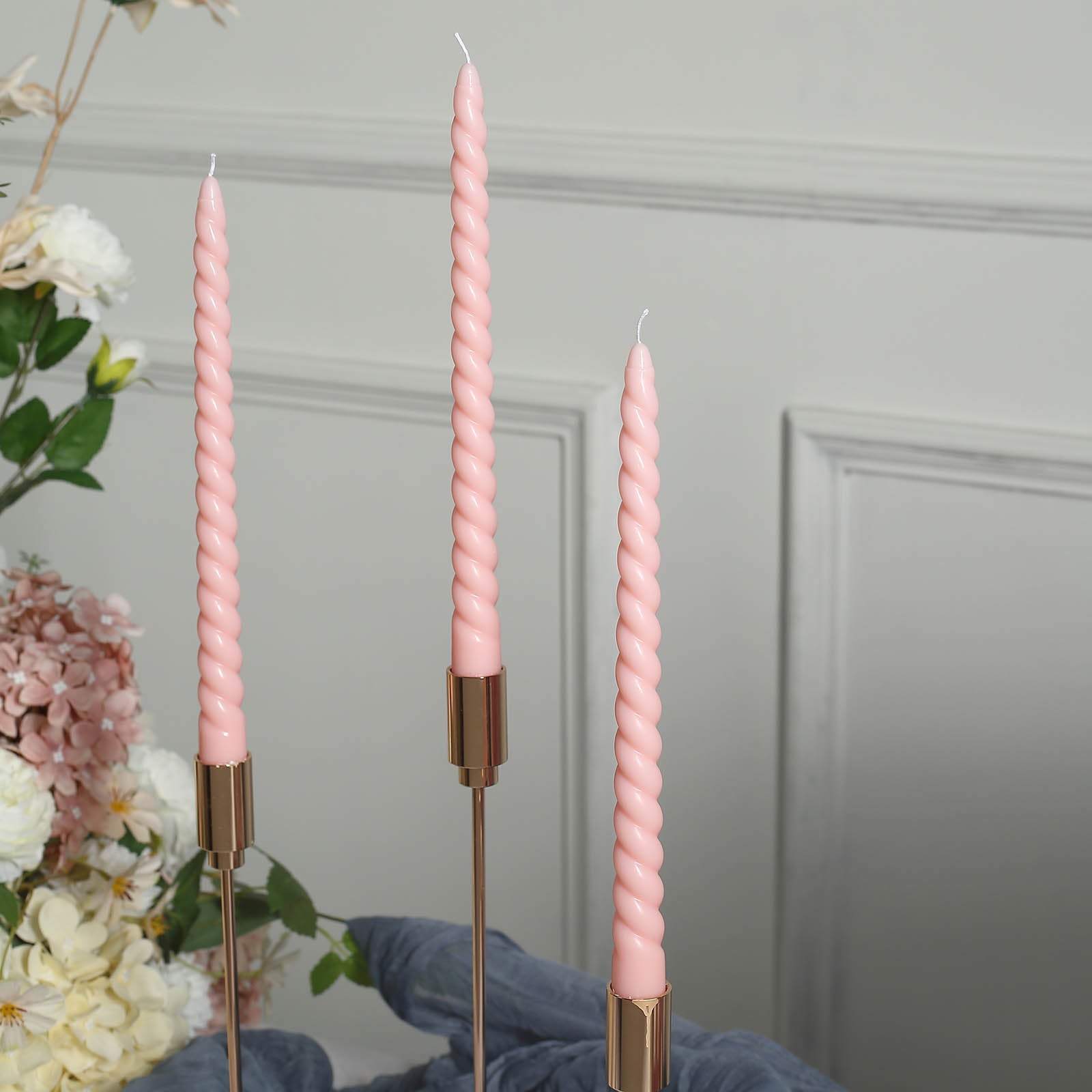 Blush premium unscented spiral wax taper candles in a floral setting.