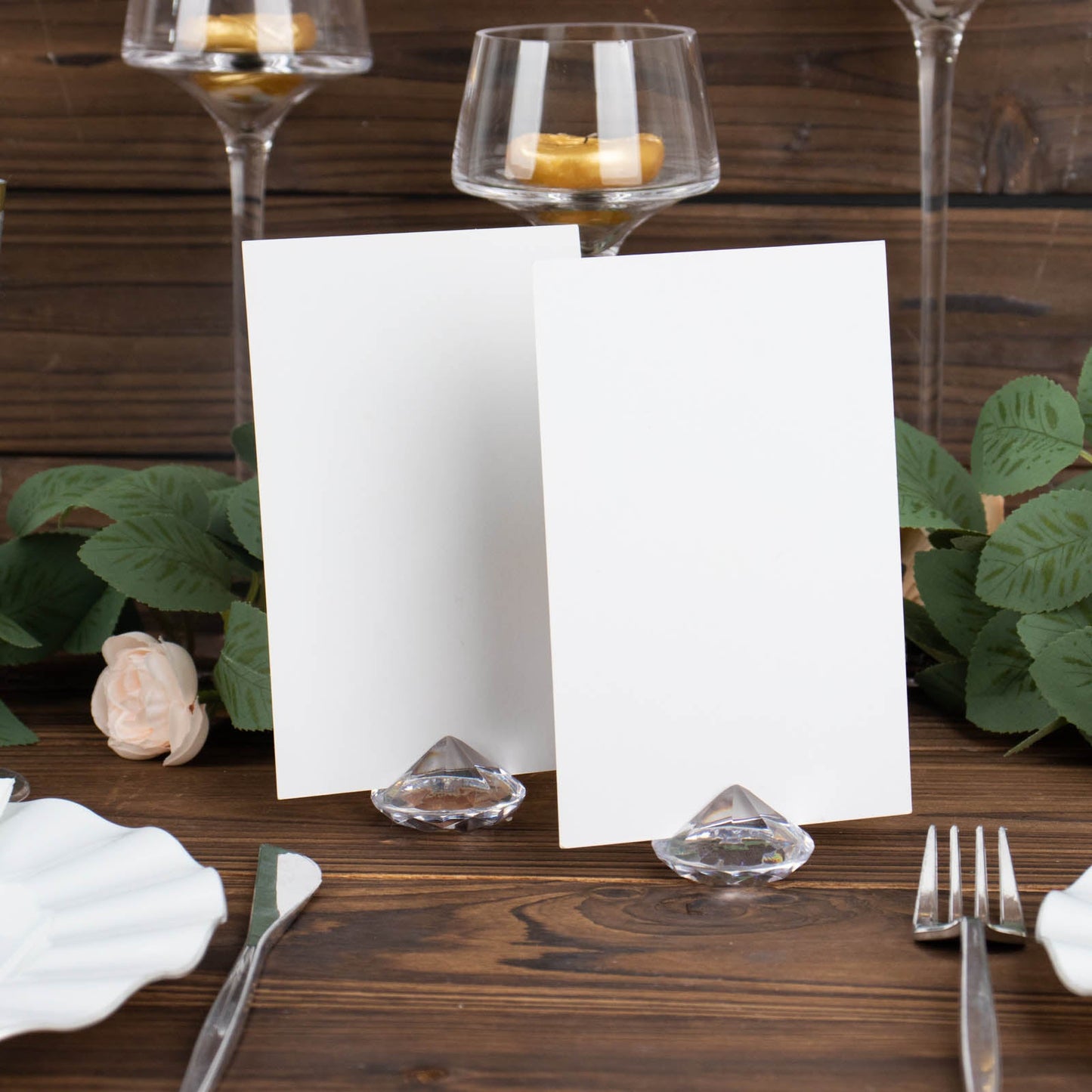 Clear plastic diamond-shaped place card holders for table decorations.