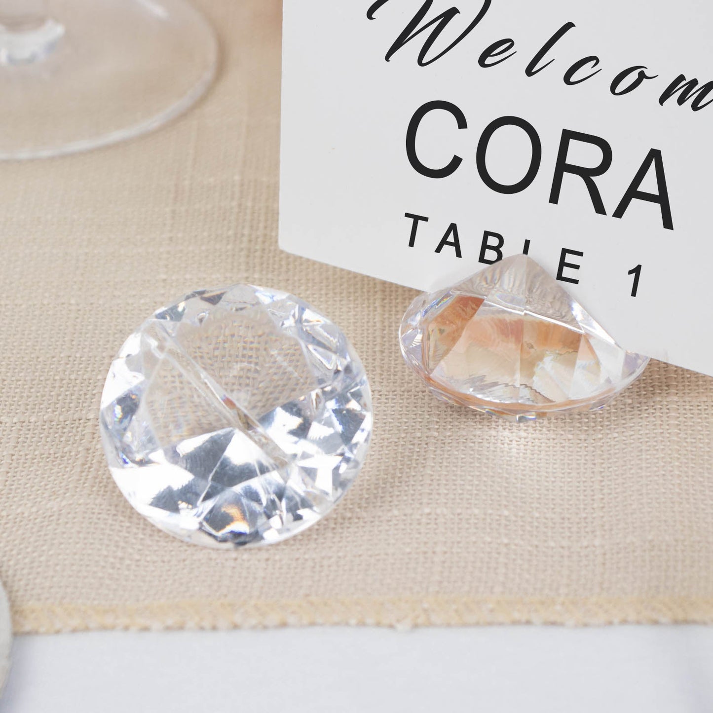 Clear plastic diamond-shaped place card holder stands for wedding table decorations.