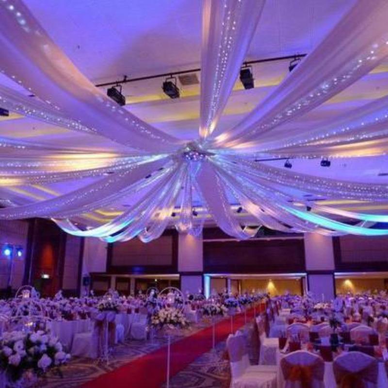 White ceiling drape with stainless steel hardware in an elegant venue setting.