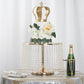 Metallic gold cake stand with crystal chains, featuring a crown cake and floral decor.