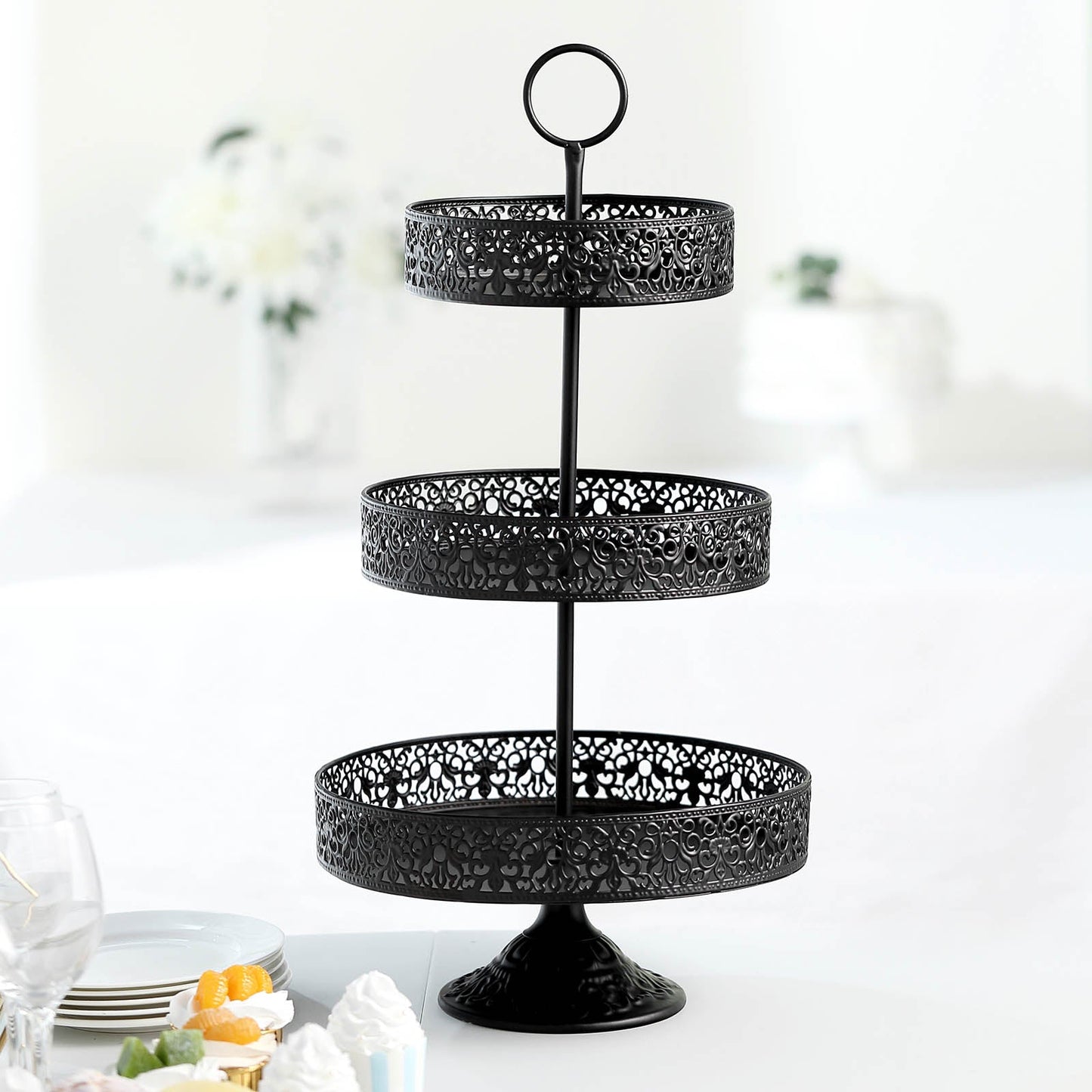 Black 3-tier metal cupcake stand for displaying desserts.