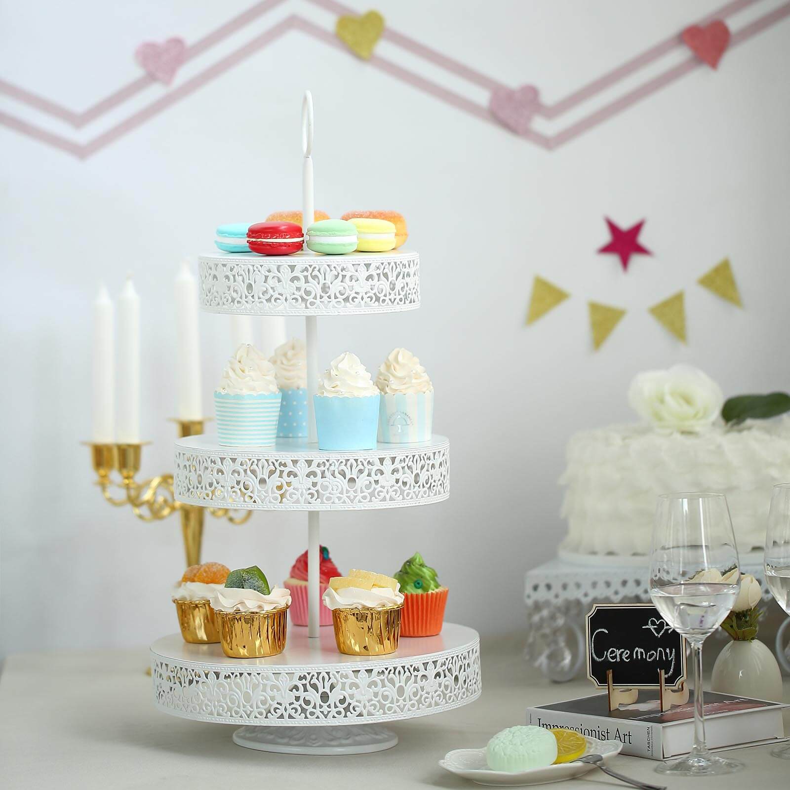 White 3-tier cupcake stand with colorful desserts displayed.