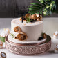 Rose gold metal wedding cake stand with a round design.