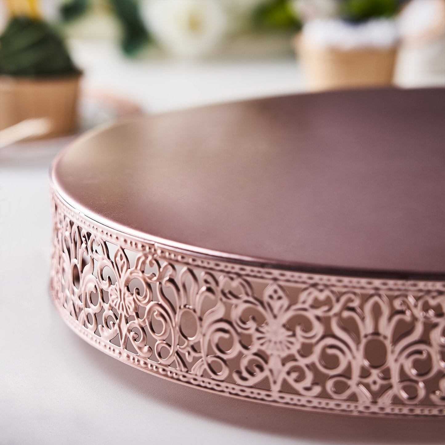 Rose gold round wedding cake stand with Fleur De Lis design.