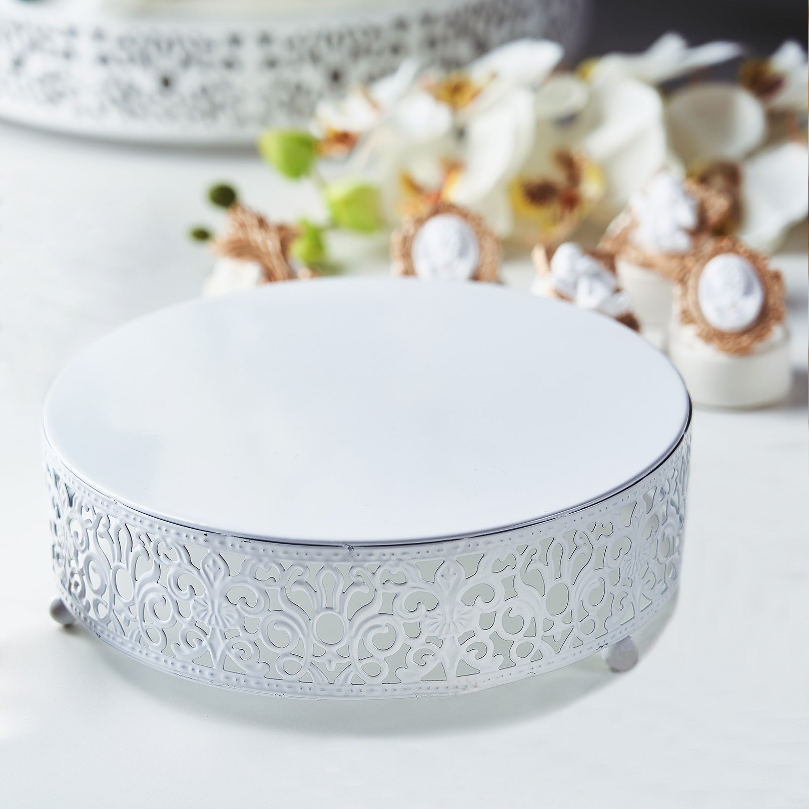 White metal wedding cake stand with Fleur De Lis design.