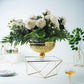 Gold geometric cake stand with square glass top, perfect for elegant displays.