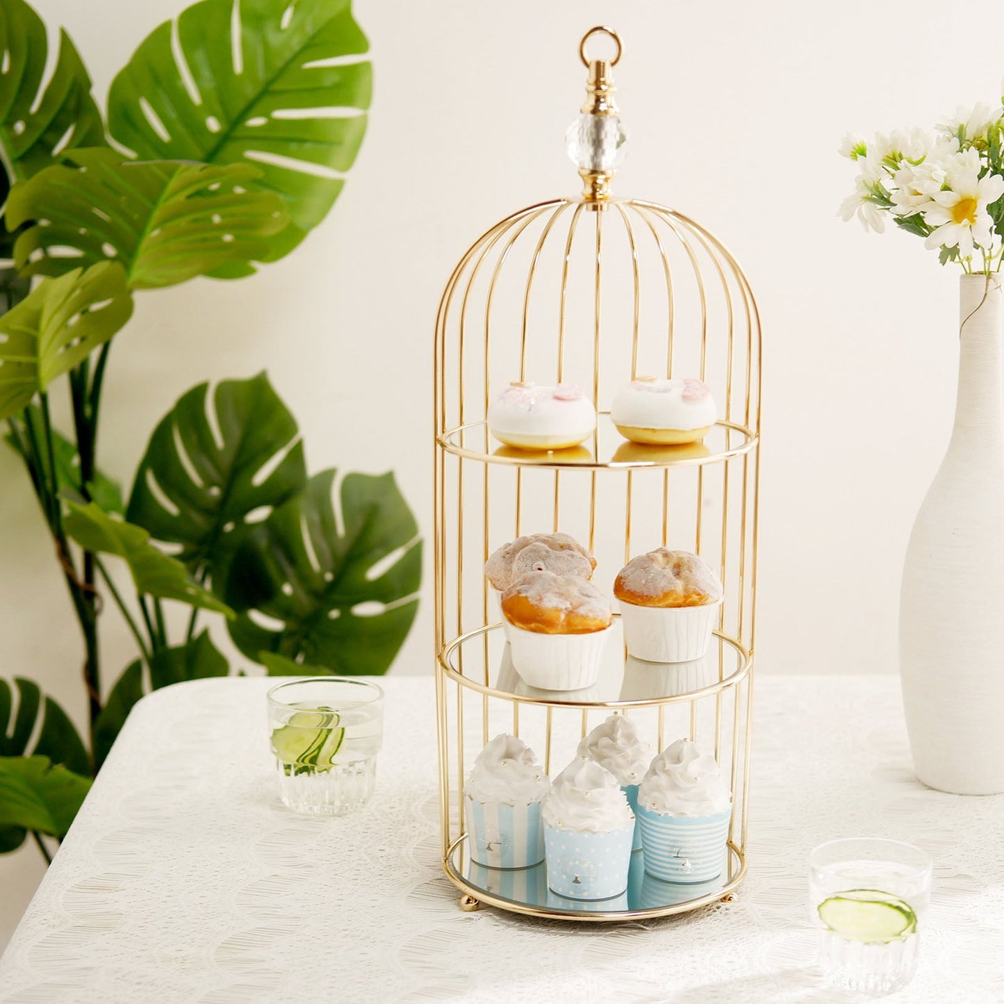 Gold 3-tier bird cage cupcake stand with mirror base, elegantly displaying treats.