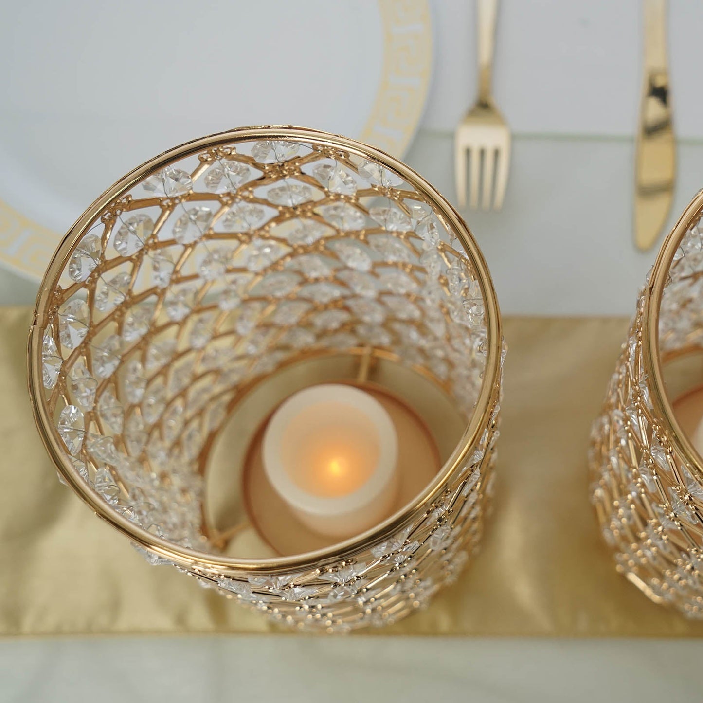 Gold crystal beaded candle holder set on a golden table runner.