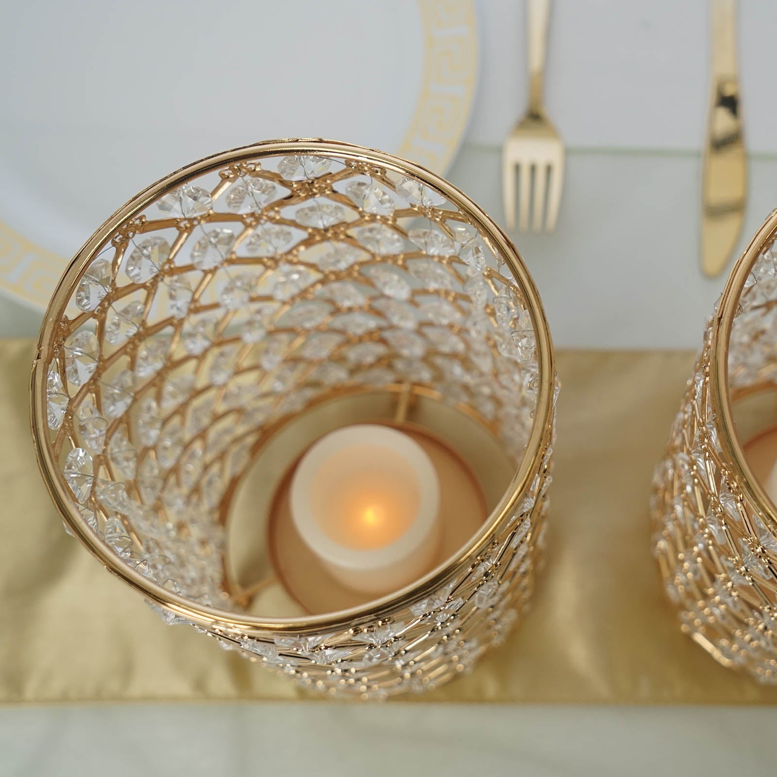 Gold crystal beaded candle holder set on a golden table runner.