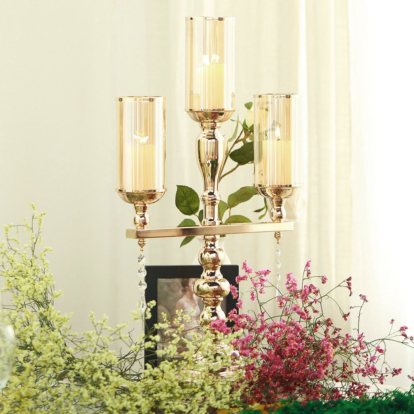 Gold 3 arm candelabra with amber glass shades and floral decor.