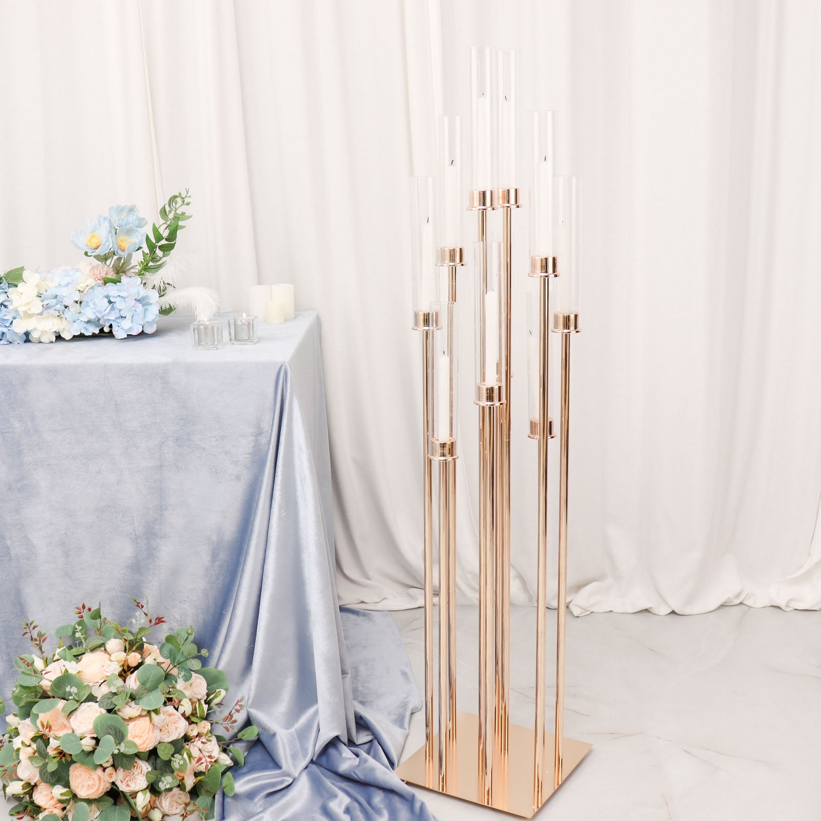 Gold taper candle holder with clear glass shades in a stylish arrangement.