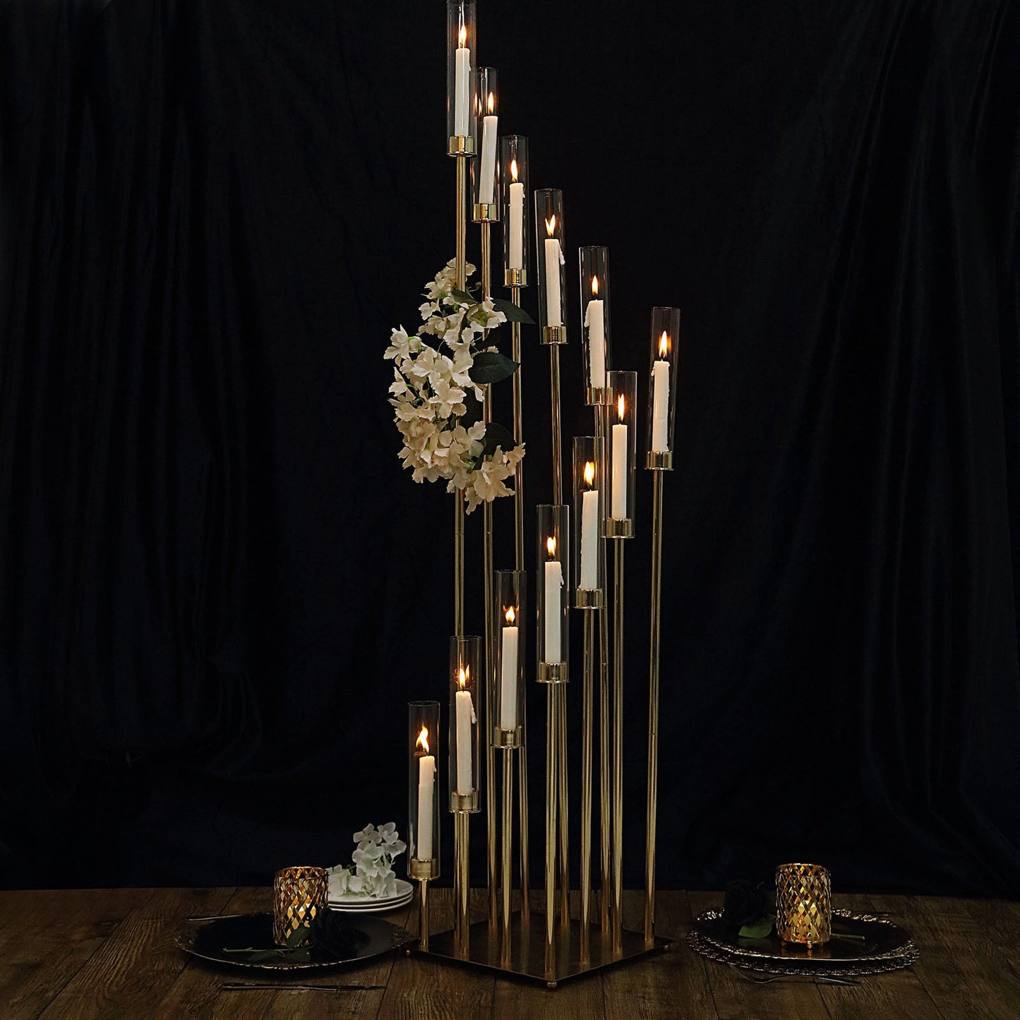 Gold 12 arm candle holder with clear glass shades and taper candles.