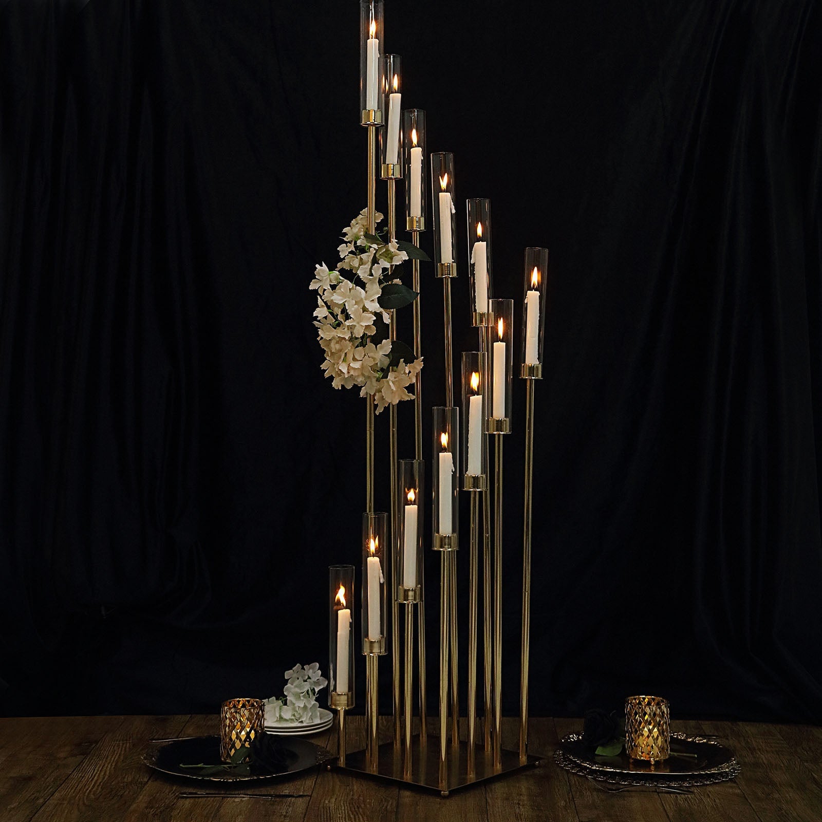 Gold 12 arm candle holder with clear glass shades and taper candles.