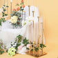 Gold 8 arm taper candle holder with clear glass shades and floral arrangement.