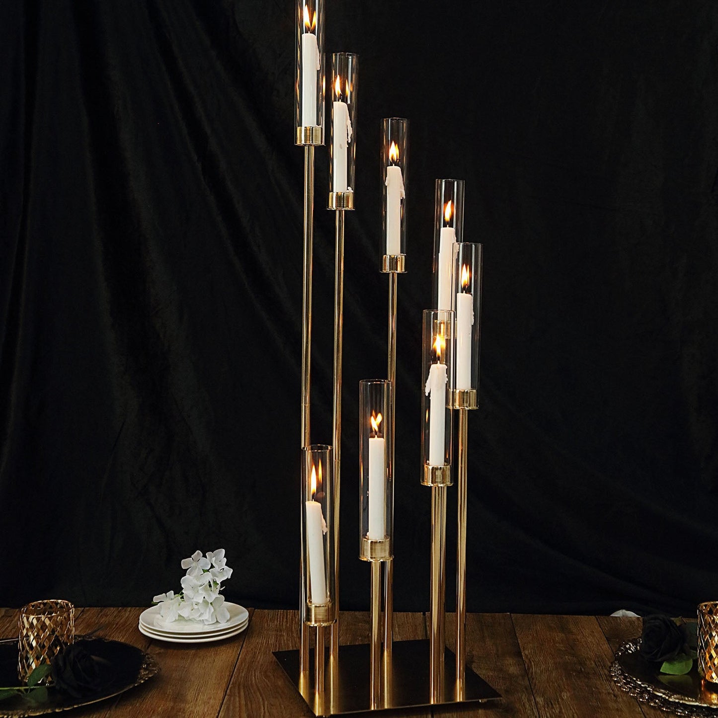 Gold 8 arm taper candle holder with clear glass shades, large candle arrangement.