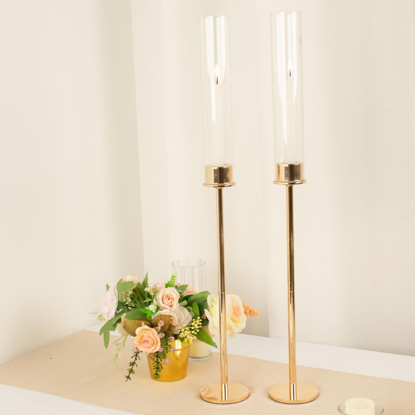 Gold metal candlestick holders with clear glass chimneys.