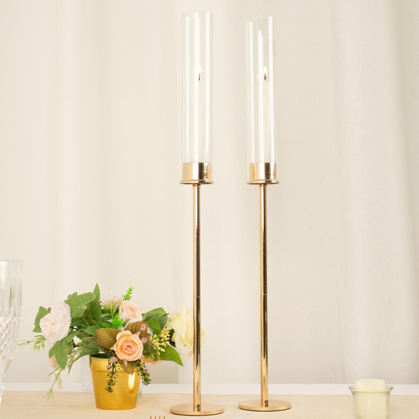 Gold metal clear glass taper candlestick holders with glass chimneys.
