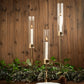 Tall gold candlestick holders with clear glass chimneys and lit candles.