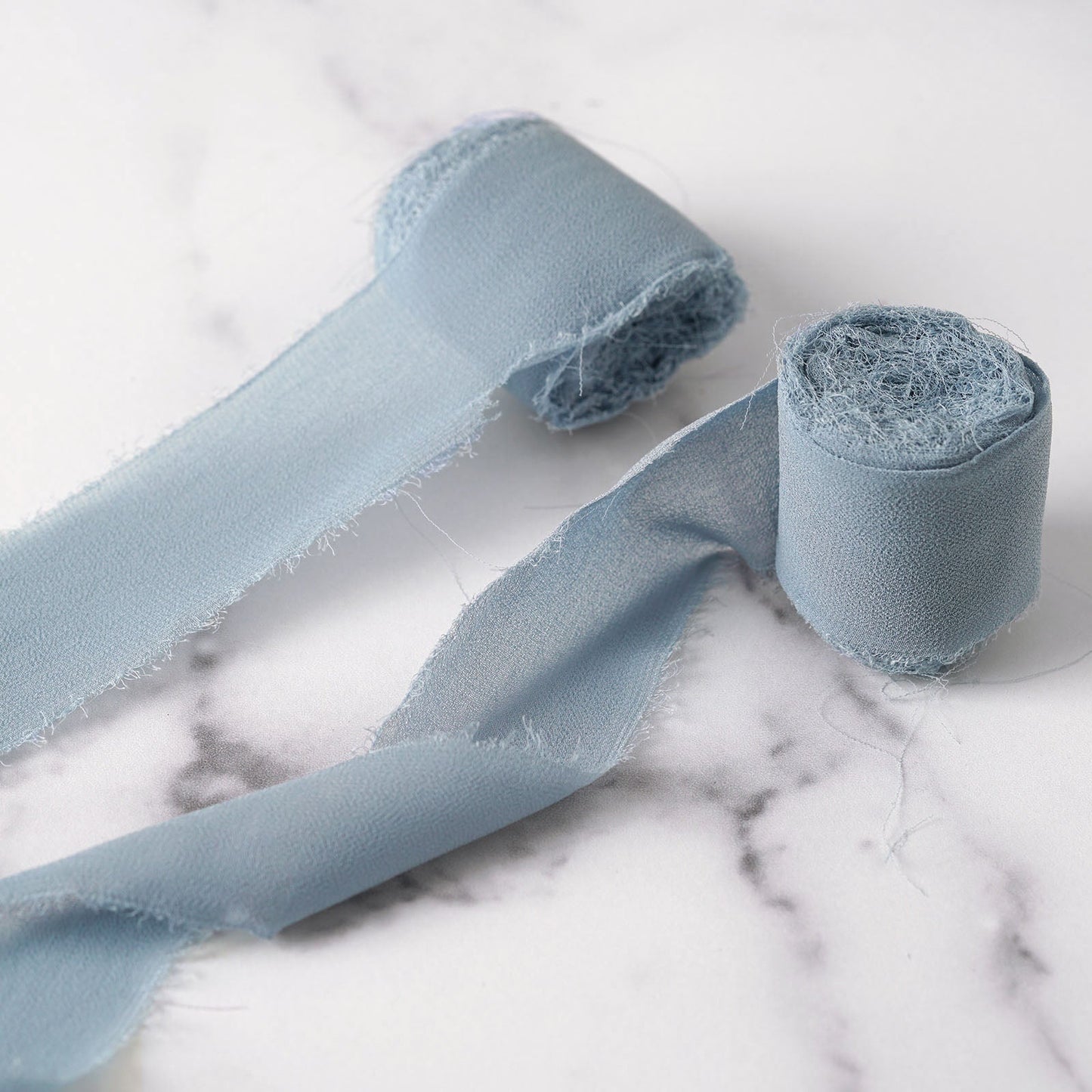 Dusty blue silk-like chiffon ribbon roll for bouquets and gift wrapping.