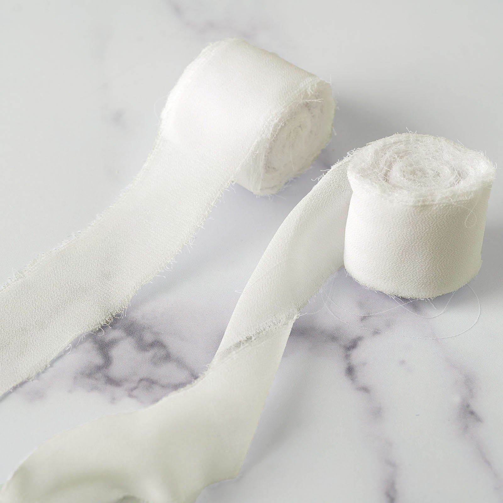Ivory silk-like chiffon ribbon rolls for bouquets and gift wrapping.