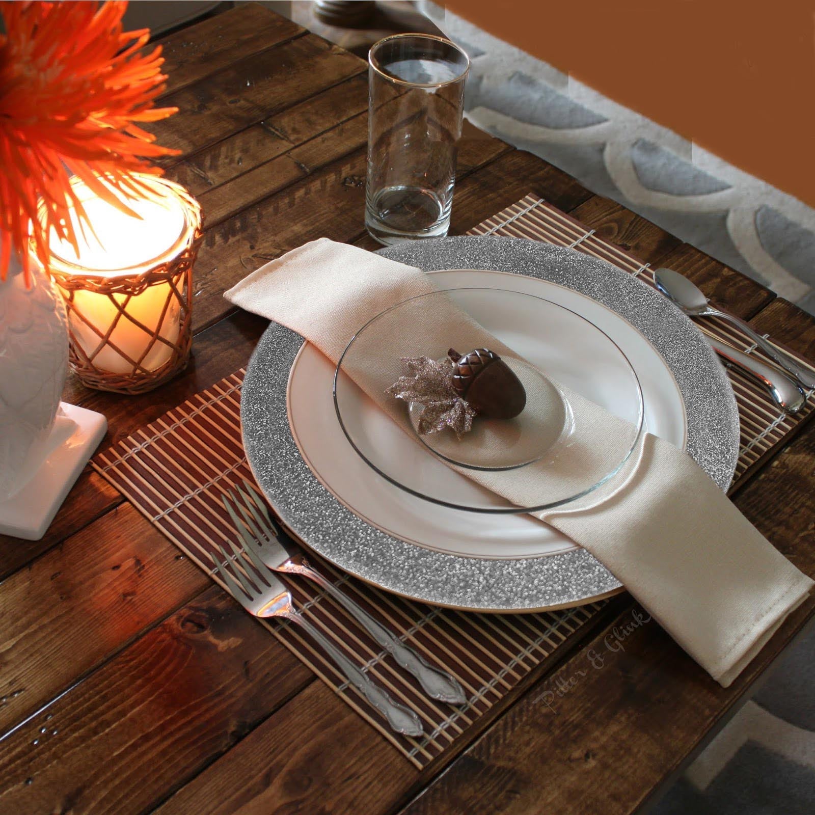 Silver glitter round charger plates on a wooden table setting.