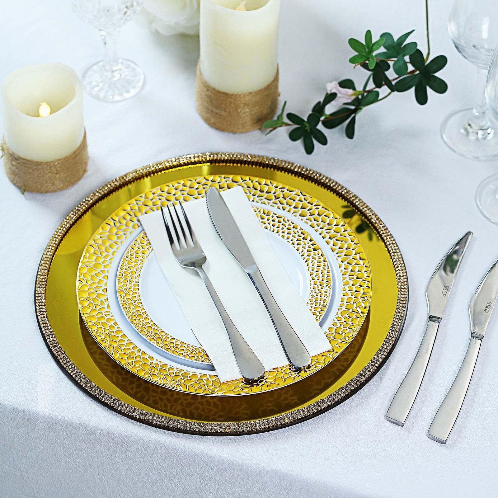 Gold metallic charger plates with rhinestone rim on a table setting.