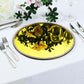 Metallic gold mirror charger plate with rhinestone rim on a table setting.