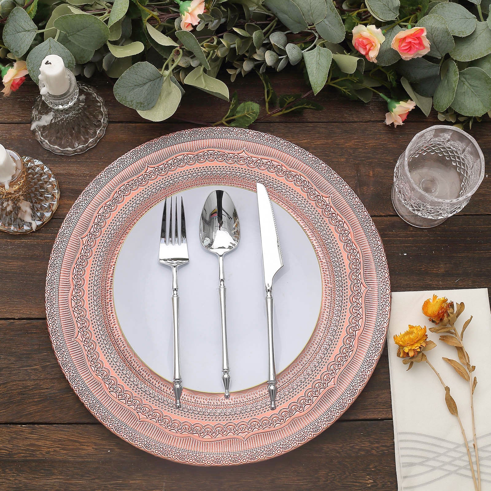 Rose gold rustic lace embossed acrylic charger plate with utensils on a table setting.