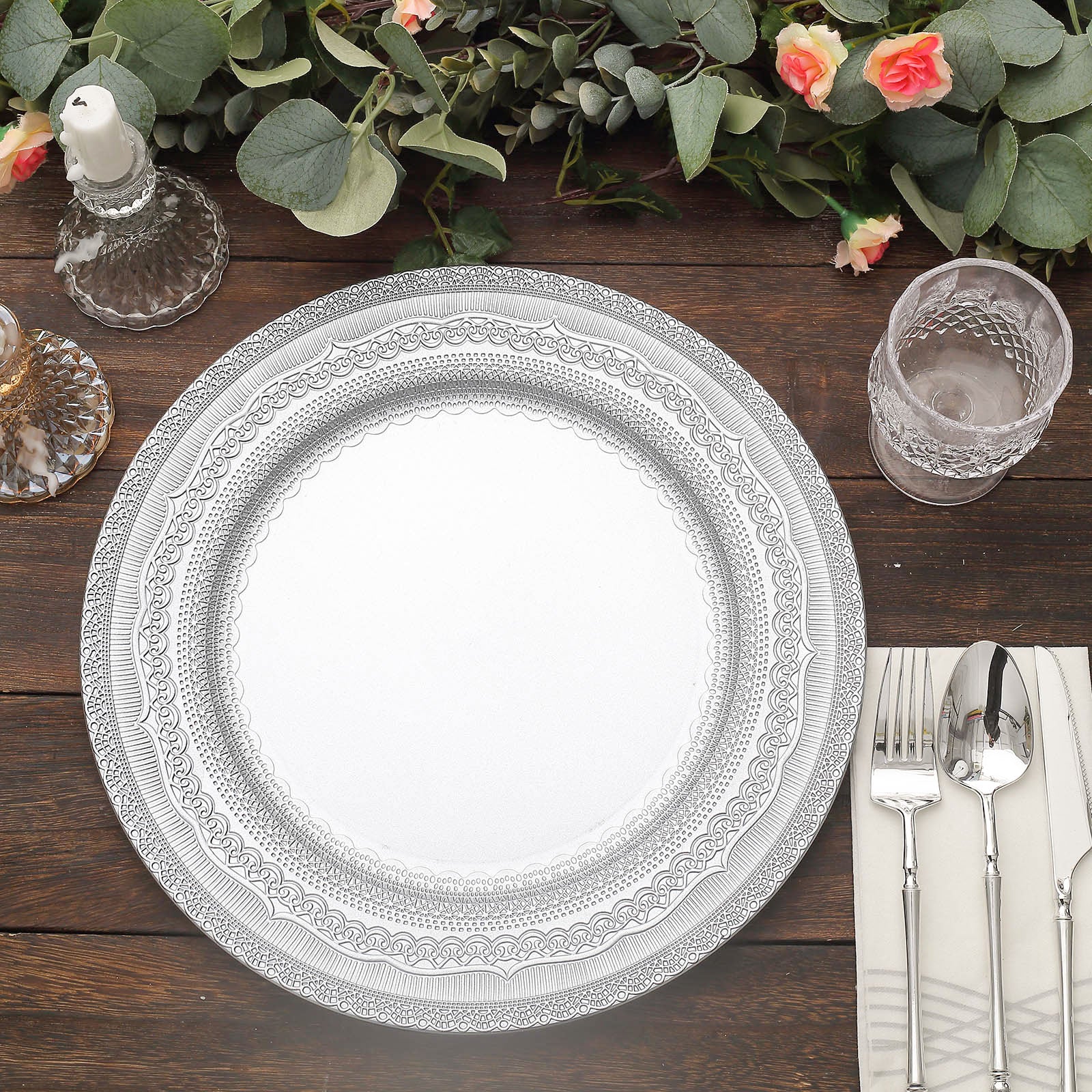 Silver rustic lace embossed acrylic charger plates on a wooden table.