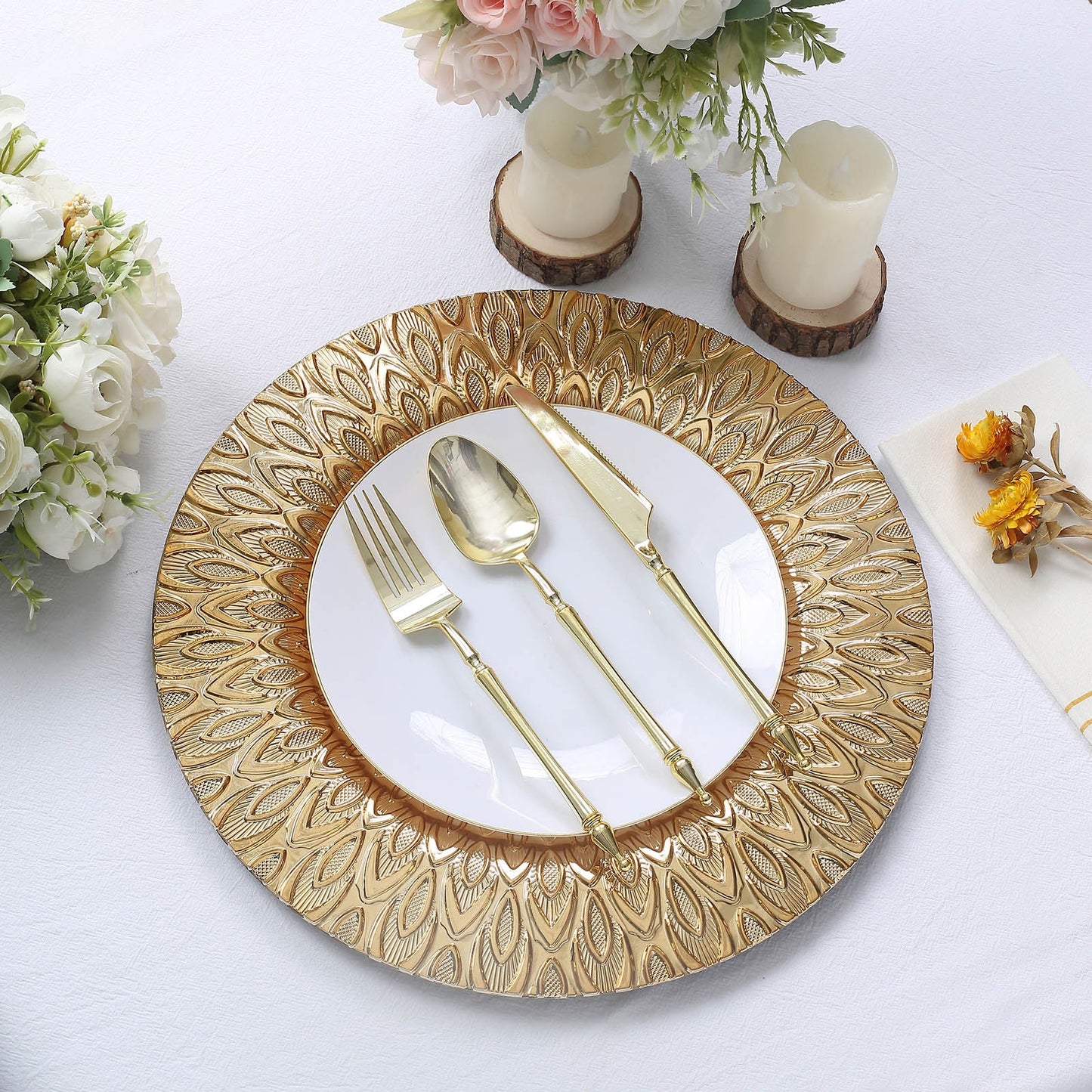 Gold embossed peacock design disposable charger plates on a table setting.
