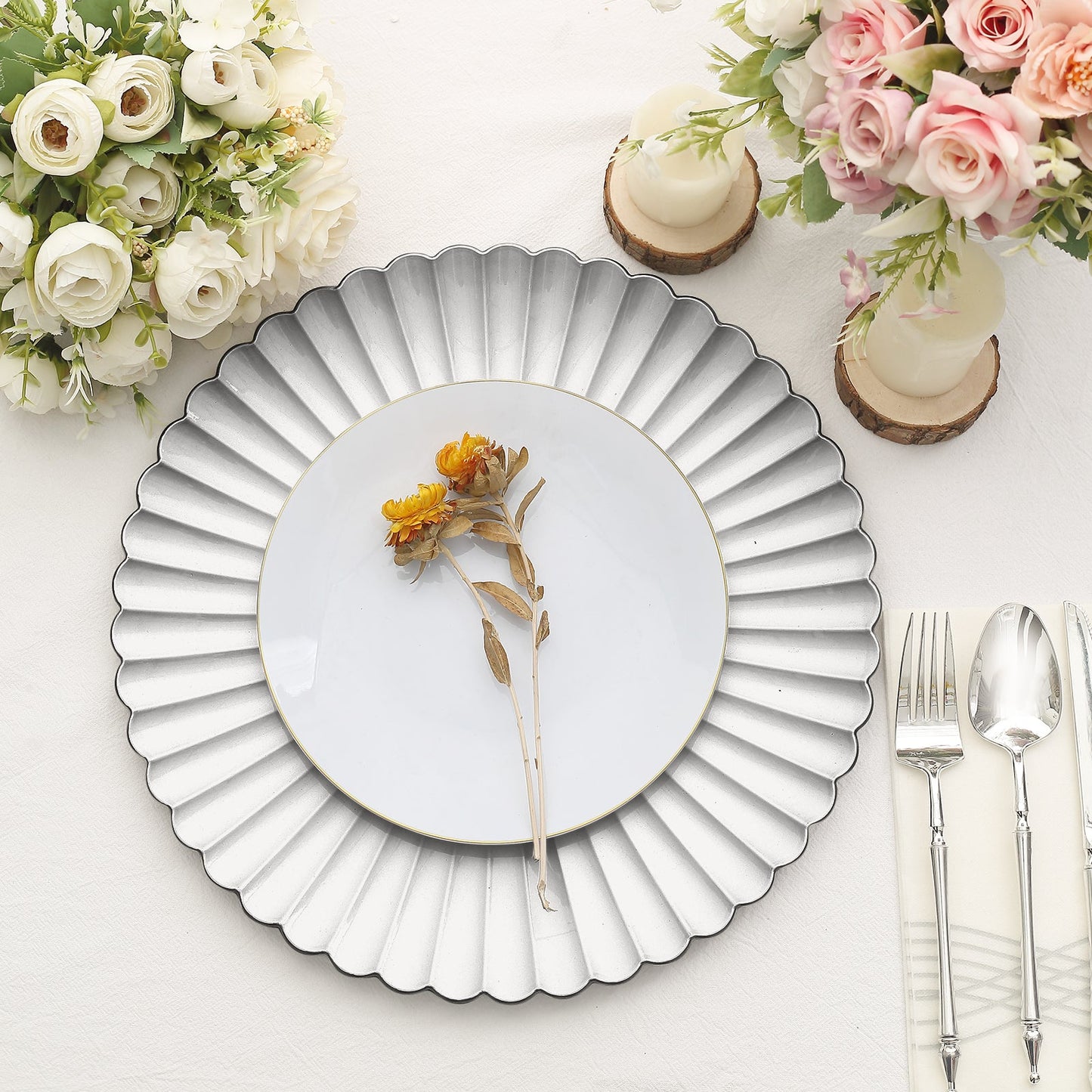 Silver scalloped shell pattern charger plate on a table setting.