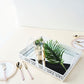 White metal decorative vanity serving tray with handles and mirrored surface.