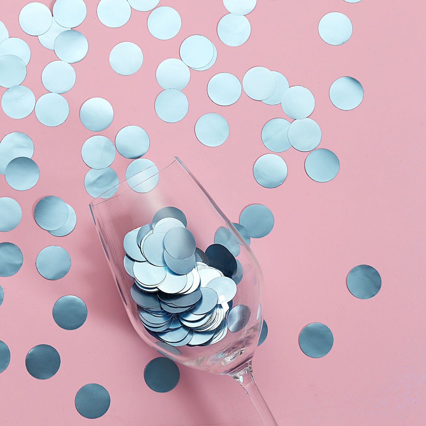 Dusty blue round foil metallic table confetti dots on a pink background.